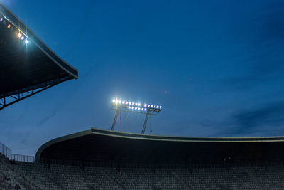 Glowing stadium lights against blue sky during blue hour