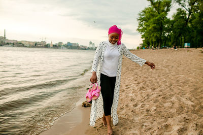 Rear view of woman standing at beach