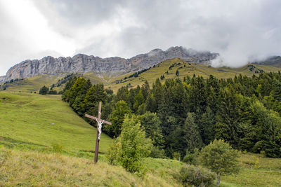 Scenic view of green landscape and mountains against sky