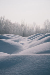 Snow covered landscape against sky