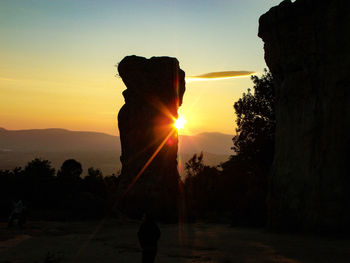 Silhouette man against orange sky during sunset