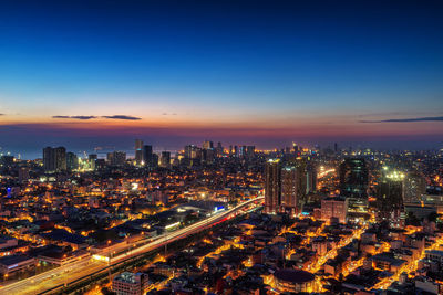 High angle view of illuminated buildings against sky at dusk