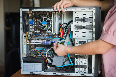 Midsection of woman repairing cpu