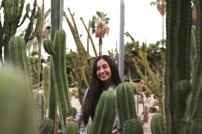 Portrait of smiling woman by cactus