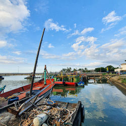 Fishing boat moored at beach against sky