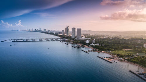 Aerial view of seascape against blue sky in city