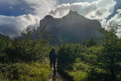 Rear view of man looking at mountains against sky