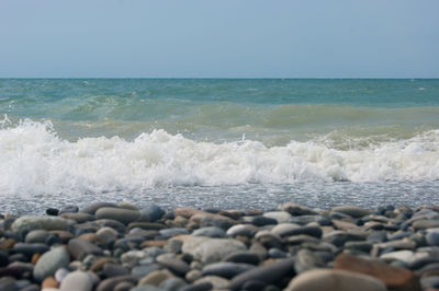 Surface level of stones on beach against sky