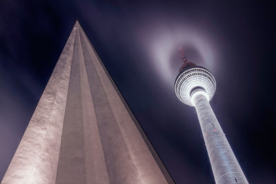 Low angle view of illuminated tower against sky at night