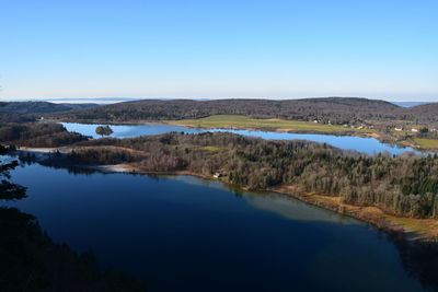 Scenic view of lake against clear blue sky