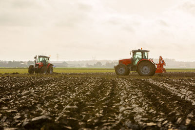 Tractor on agricultural field against sky