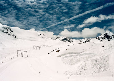 Scenic view of snowcapped mountains against cloudy sky