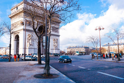 Cars on street in city against sky