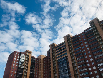 Low angle view of buildings against cloudy sky