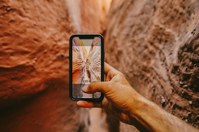 Taking picture with phone of narrow slot canyons in escalante, utah