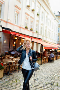 Portrait of young woman standing in city