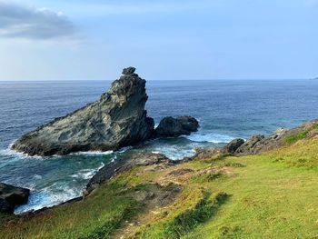 Scenic view of rocks on beach against sky