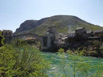 Arch bridge over river against clear sky