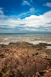 Rocky sea beach with crashing waves at morning from flat angle