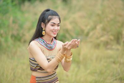 Young woman smiling while standing on field