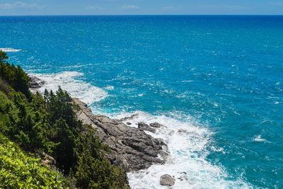 High angle view of sea shore against blue sky