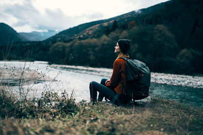 Rear view of woman sitting on mountain