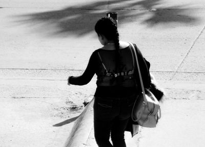 Rear view of woman walking on street in city