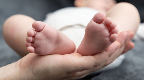 Close-up of cropped mother holding baby feet