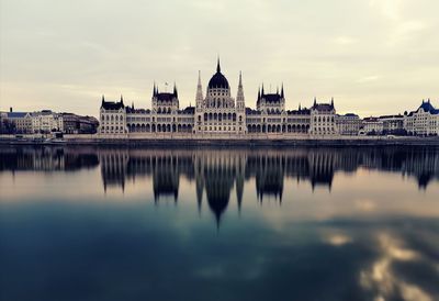 Reflection of building in river with city in background