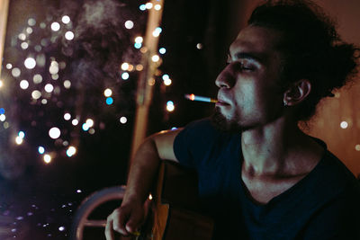 Man smoking cigarette while playing guitar during christmas