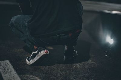 Low section of man sitting on street