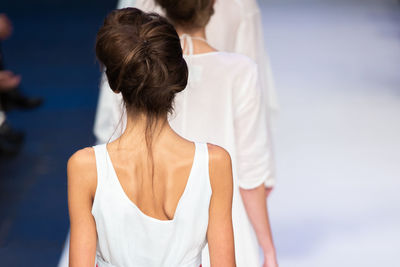 Rear view of models walking on ramp walk