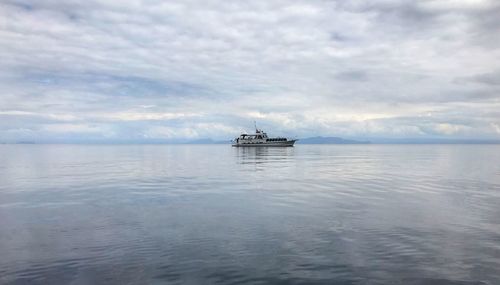 Boat sailing in sea against sky