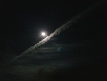 Low angle view of vapor trails in sky at night