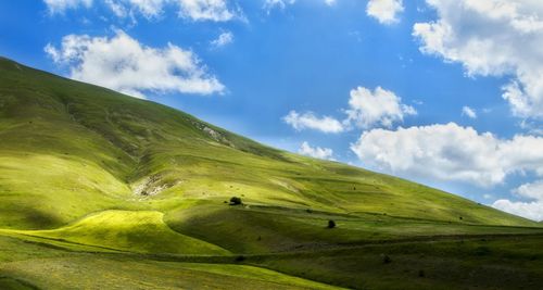 Low angle view of landscape against cloudy sky