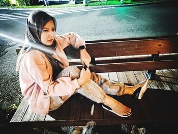 High angle view of woman sitting by railing