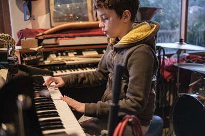 Rear view of man playing piano