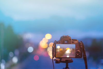 Close-up of camera against sky at dusk