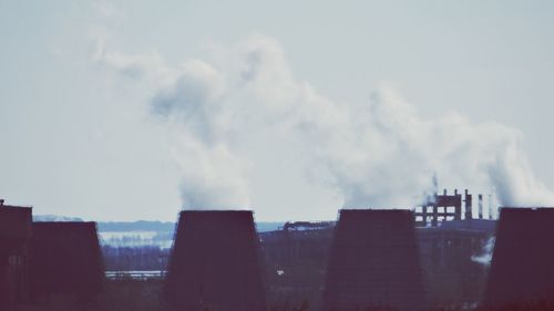 Smoke emitting from chimney against sky