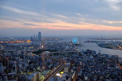 High angle view of city lit up at sunset