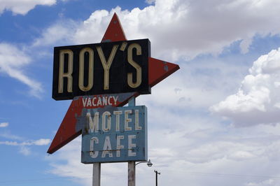 Low angle view of road sign against sky