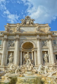 Low angle view of statues and historic building at trevi fountain