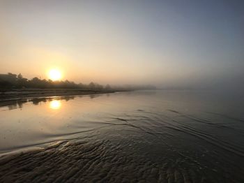 Scenic view of lake against clear sky during sunset