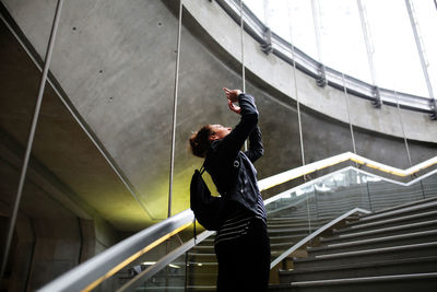 Low angle view of woman standing on escalator