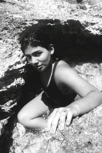 Portrait of young woman sitting on rock