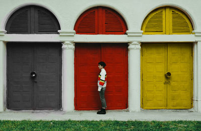 Rear view of woman standing against wall