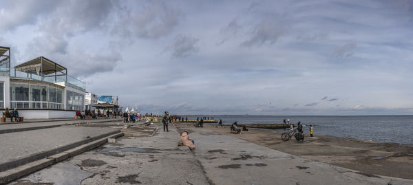 People walk by the sea on a cloudy winter day on lanzheron beach in odessa, ukraine