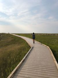 Rear view of woman walking on footpath