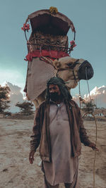 Man standing with camel against sky