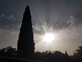 Low angle view of sun shining through clouds